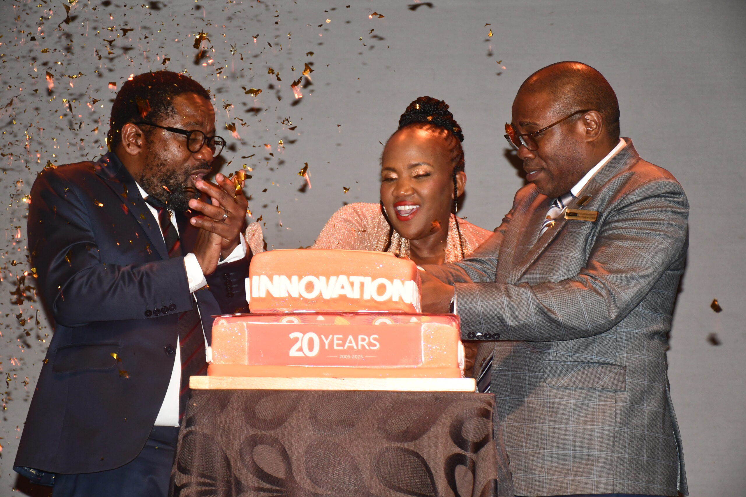 From left - Prof Bongani Ngqulunga, Ms Nomsa Mahlangu and VC Prof Letlhokwa Mpedi cut a cake in celebration of UJ at 20