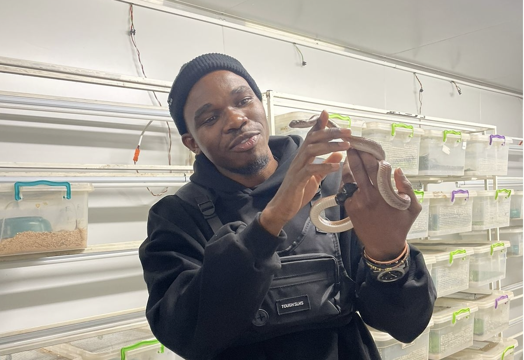 Mr Isac Mabunda interacting with a non-venomous snake during the field trip