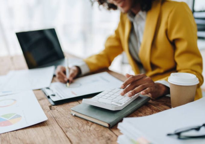 Young asian female work with financial papers at home count on calculator before paying taxes receipts online, planning budget glad to find chance for economy saving money, audit concepts